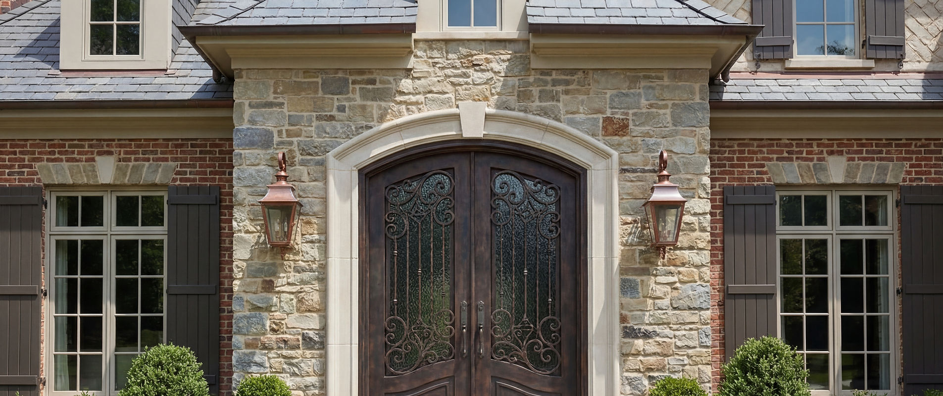 Please create an image of a high end iron front door on a traditional home that  (2).jpeg